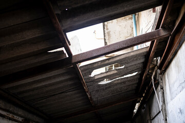 Hold on the roof after rain storm in the abandoned house. Damaged of old double cement roof and...