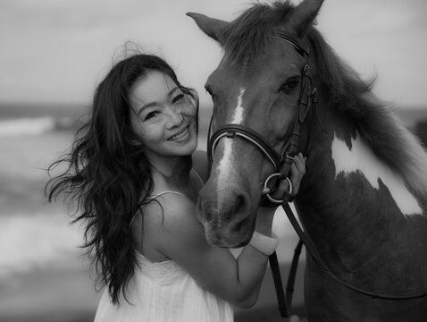 Monochrome. Portrait of smiling woman and horse. Woman hugging horse. Romantic concept. Love to animals. Black-white photo. Nature concept. Bali