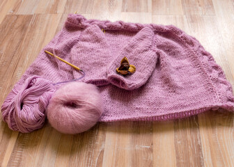 Fototapeta na wymiar knitted jacket for a girl, pink color, knitting texture, handicraft concept, hand knitting, autumn