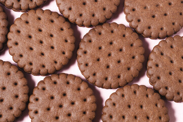 Texture background of rows of chocolate-cream cookies.