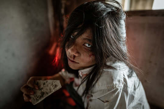 Young Asian zombie eats corpses in an abandoned building.