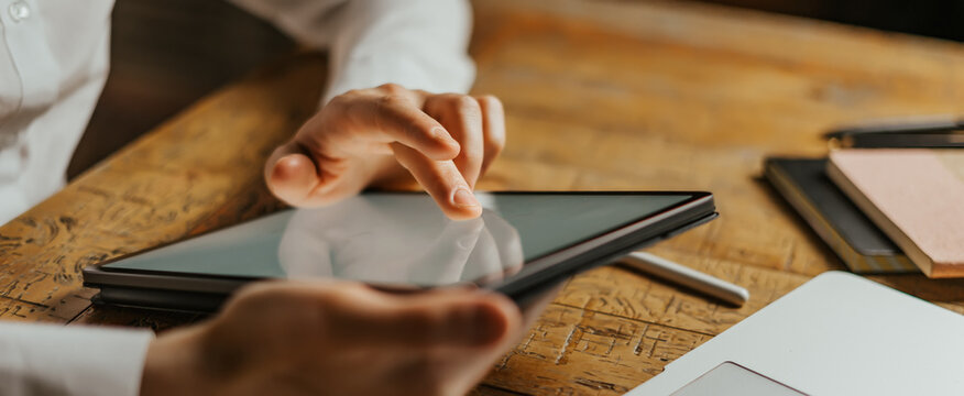 Male hands tapping on digital tablet screen. Close-up photo