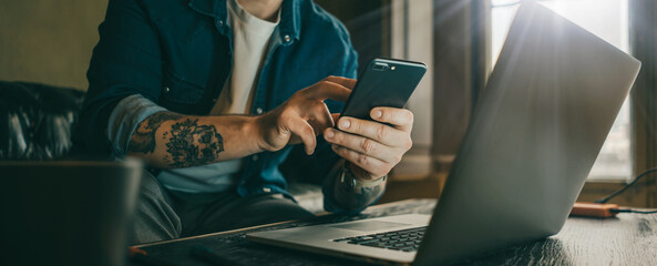 Man pointing on smartphone screen, chatting in social networks, meeting website, searching internet, using text messenger or online banking. Close up of male hands. Remote work