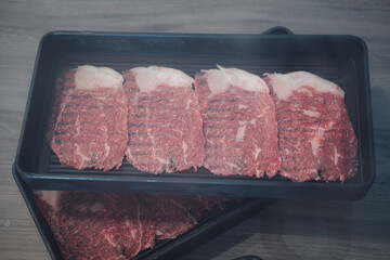Thin sliced premium wagyu beef on black tray for Shabu Shabu
