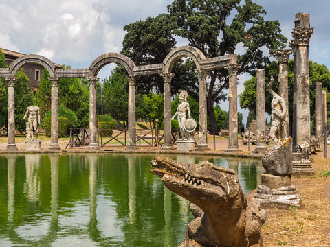 Ruined columns, marble sculptures and crocodile on the curved side of the canal-pool Canopo. Beautiful architectural park, created of emperor Hadrian, known as Villa Adriana. It is in Tivoli, Italy.