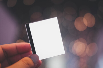 Male hand holding blank sheets of paper on bokeh light background