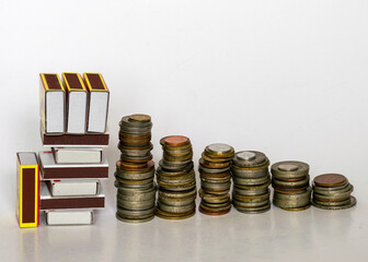 metal coins of different shapes, countries and values, match boxes symbolize the concept of house, money storage and savings