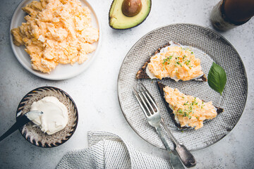 Scrambled egg sandwich with cream cheese on rye toast for breakfast on white background, top view. Healthy breakfast or snack