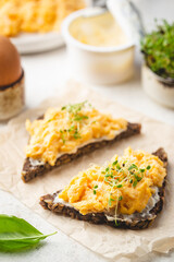 Scrambled egg sandwich with cream cheese on rye toast for breakfast on white background. Healthy breakfast or snack