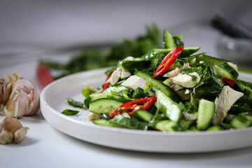 Salad with cucumbers, green onions, cilantro, chicken breast and chili. Asian-style salad.

