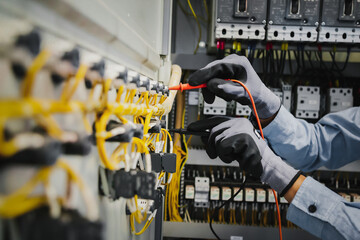 Electrical engineers test electrical installations and wiring on protective relays, measuring them...