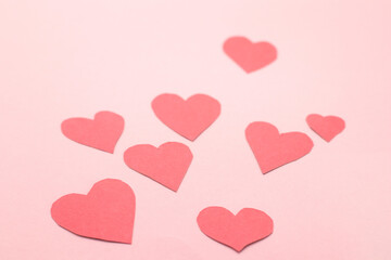 Concept for Valentine's Day February 14th. Red Valentine's Day hearts cards on pink background.