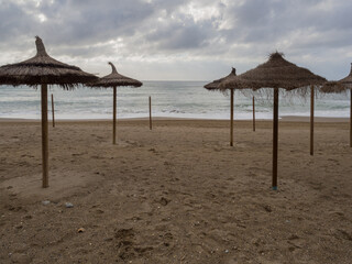 Mediterranean Sea views from the beach next to a straw umbrella in winter