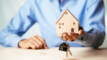 House model with real estate agent and customer discussing for contract to buy house, insurance or...