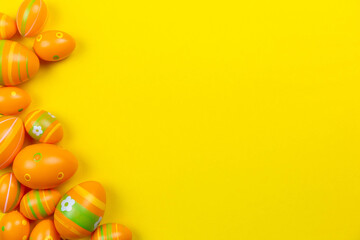 Colorful easter painted eggs background on yellow colorful background flat lay. Easter holiday concept. Traditional decoration for springtime holiday. Top view. Copy space.