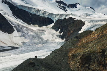 two alpinists on a snow covered mountain near base camp