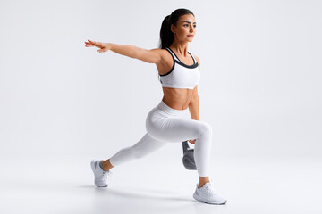 Fitness woman doing lunges exercises with kettlebell, leg muscle training. Active girl doing front forward one leg step lunge - obrazy, fototapety, plakaty