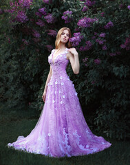 Beautiful blonde girl in violet dress in lilac tree © Альбина Хусаинова