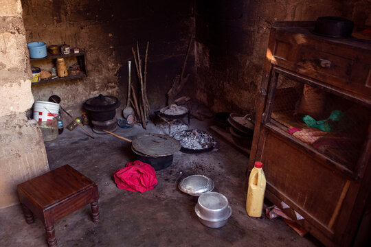 African kitchen interior with hearth  and stove. Interior of the modest vintage style poor kitchen, pots and utensils  lay on the ground. Real life modest kitchen in african village.