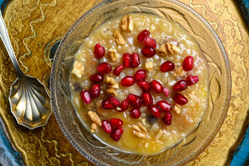 Ashure or Noah's pudding, the turkish dessert porridge in glass bowl on golden dish