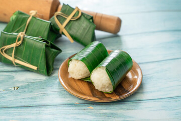 Fototapeta na wymiar traditional indonesian food. asian culinary lemper. rice cake with banana leaf and chicken inside, 