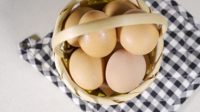 hand putting an egg inside a basket full of eggs, concept of classic American proverb Never put all your eggs in one basket. Idea of financial risks
