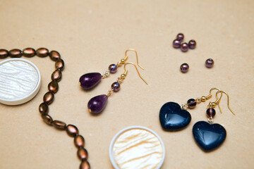 Handmade gemstone earrings. Amethysts, aventurine and glass beads on a cardboard background. Women's Jewelry