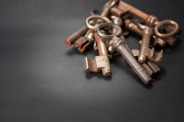 Aufgehäufte alte Buntbartschlüssel Sie sind unterschiedlich rostig und liegen auf einem schwarzen  Untergrund