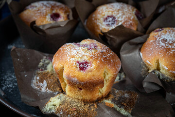 Kefir cupcakes with orange zest and raspberries, powdered with sugar.