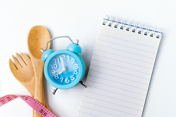 Food clock with notebook. Healthy food concept on white background