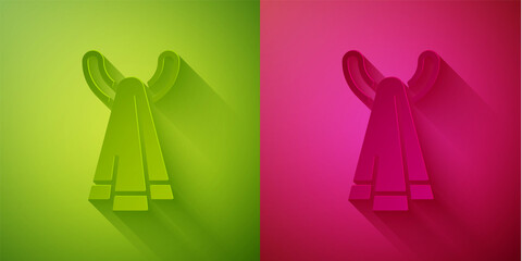 Paper cut Towel on a hanger icon isolated on green and pink background. Bathroom towel icon. Paper art style. Vector.