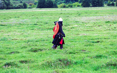 Soldier in historical costume goes in the summer field