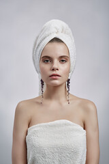 Beautiful woman in towel and earrings