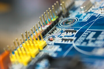 The reverse side of the colorful microboard on a blue background. Electronic board with electrical components, computer equipment.