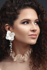 Curly beauty brunette with earrings.