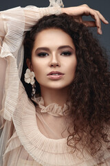 Curly beauty brunette with earrings.