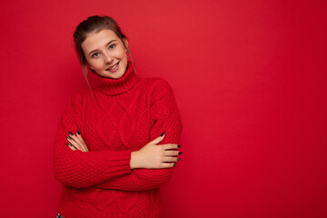 Obraz premium Young happy smiling attractive brunette woman with sincere emotions isolated on background wall with copy space wearing casual red sweater. Positive concept