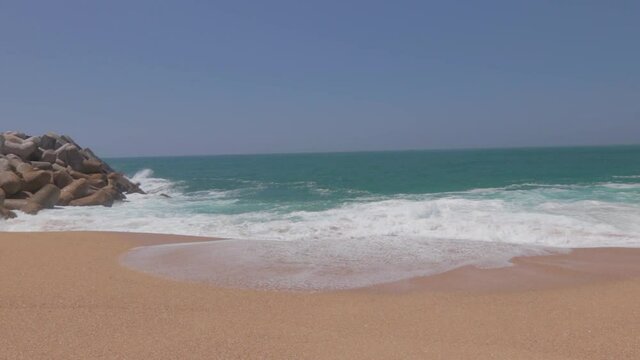 Paisaje de la playa de Nazar&eacute; con las olas rompiendo en la arena