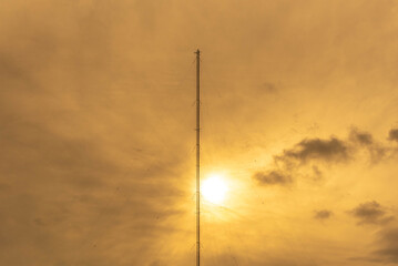 Obraz premium Radio Frequency Modulated Wave Transmission Tower - FM in contrast with the sunset