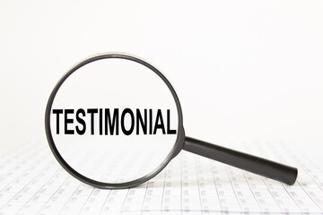 words TESTIMONIAL in a magnifying glass on a white background. business concept