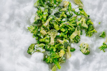 Top view of green broccoli laid frozen on a grinded ice. Cut in short brunches.