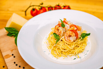 spaghetti with shrimps and tomatoes on a decorated table