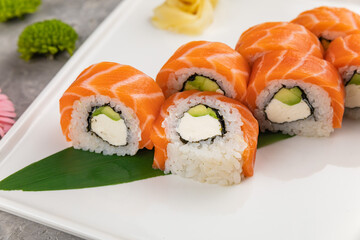 Japanese cuisine. Sushi roll with salmon on grey  background.