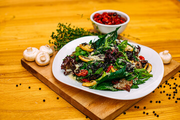 salad with meat, mushrooms and sun-dried tomatoes on a decorated table