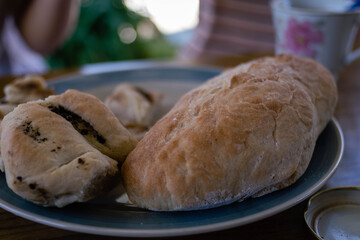 Hot homemade bread with moisture vapor freshly made in a Chilean clay oven with white flour and women's hands Cordoba Argentina