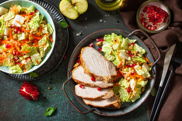Healthly food. Baked meat steak salad and Chinese cabbage salad with apple, pomegranate, walnuts and on a stone tabletop. Top view flat lay.