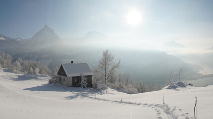 romantisches Häuschen in frisch verschneiter Winterlandschaft