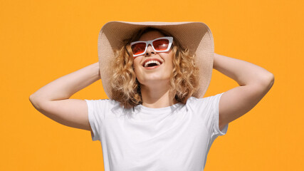 Portrait of happy pretty woman wearing hat and in stylish sunglasses, smiling, looking at sun with...
