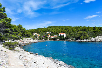 Beautiful Adriatic sea in Croatia in summer. Blue lagoon, green pines, stony coast. Footpath along the sea.Bright landscape. Mudri Dolac, Basina bay