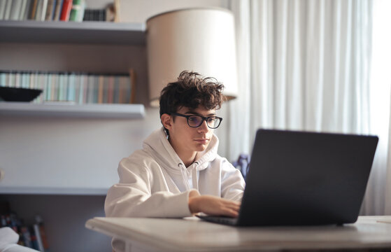 portrait of teenager with glasses while working on the computer